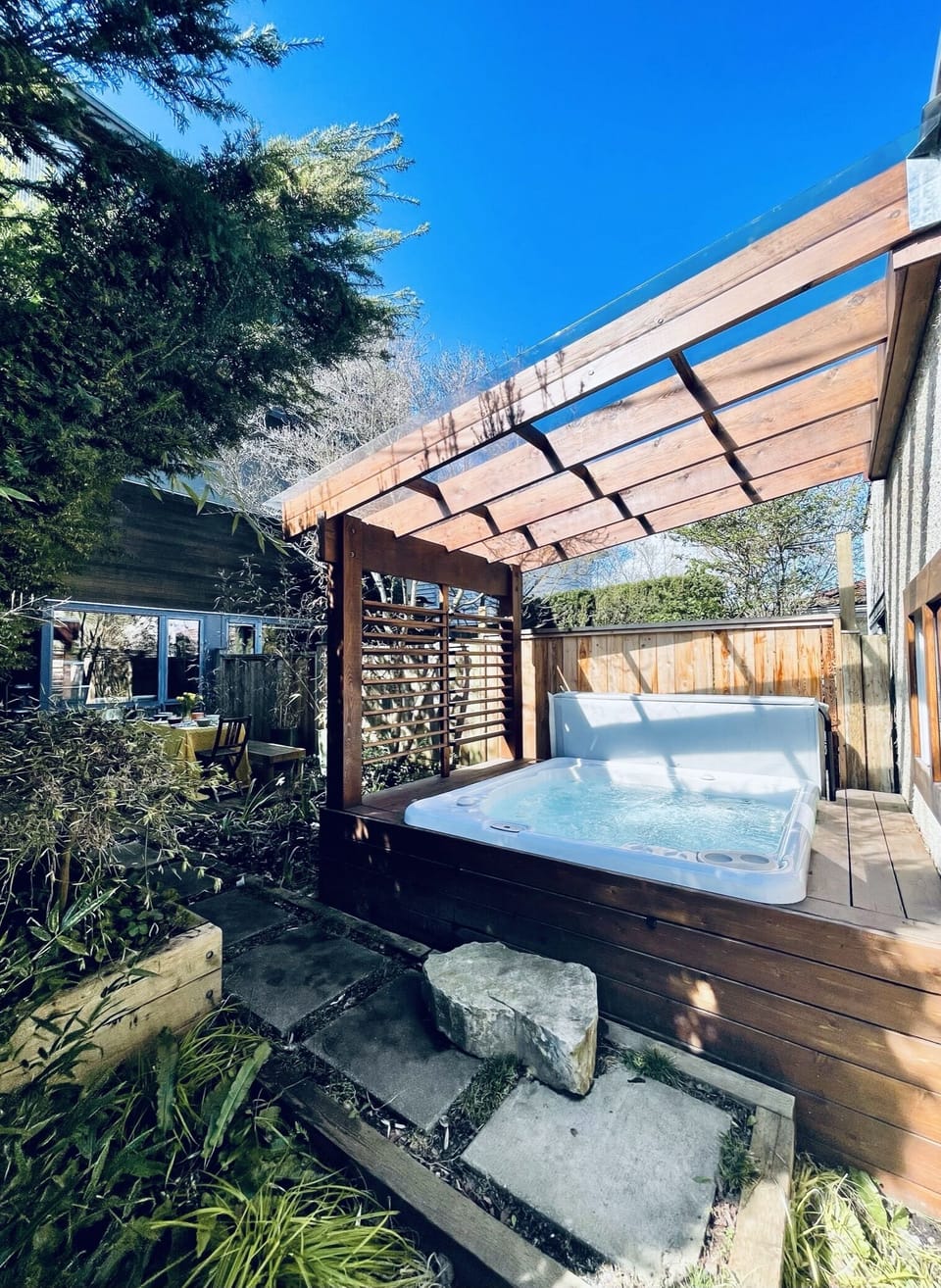 Unwind after a day of adventuring  in a private hot tub with covered clear roof.