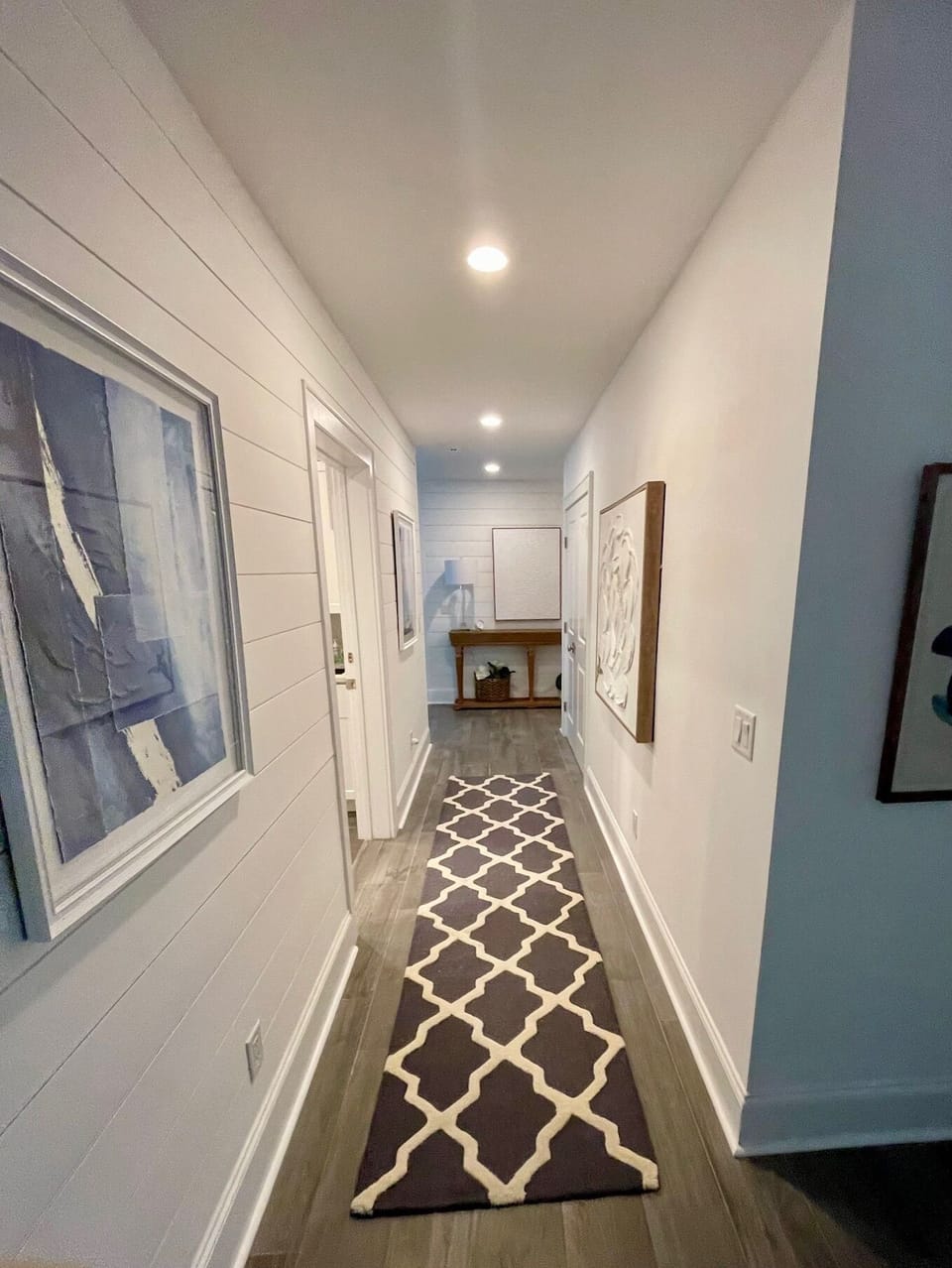 1st Floor Hallway that includes a laundry room with full washer and dryer, plus a full refrigerator for extra space.  This leads from the 1st floor bedrooms to the living space off of the pool deck.
