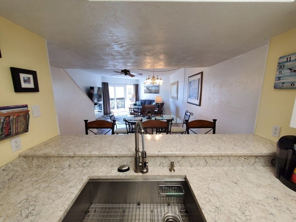 View through kitchen bar to a spacious dining and living area.