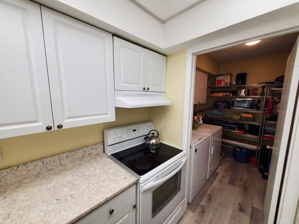 Compact kitchen leading to a fully stocked pantry, ideal for home-cooked meals.