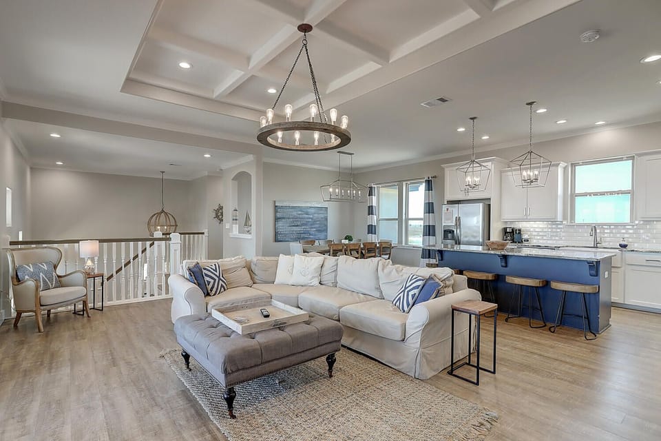 Relax in your spacious open-concept living area with soaring ceilings, elegant chandeliers, and a fully equipped gourmet kitchen perfect for gatherings.