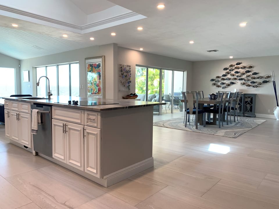 Open concept kitchen, dining, and family room with walls of sliding glass.