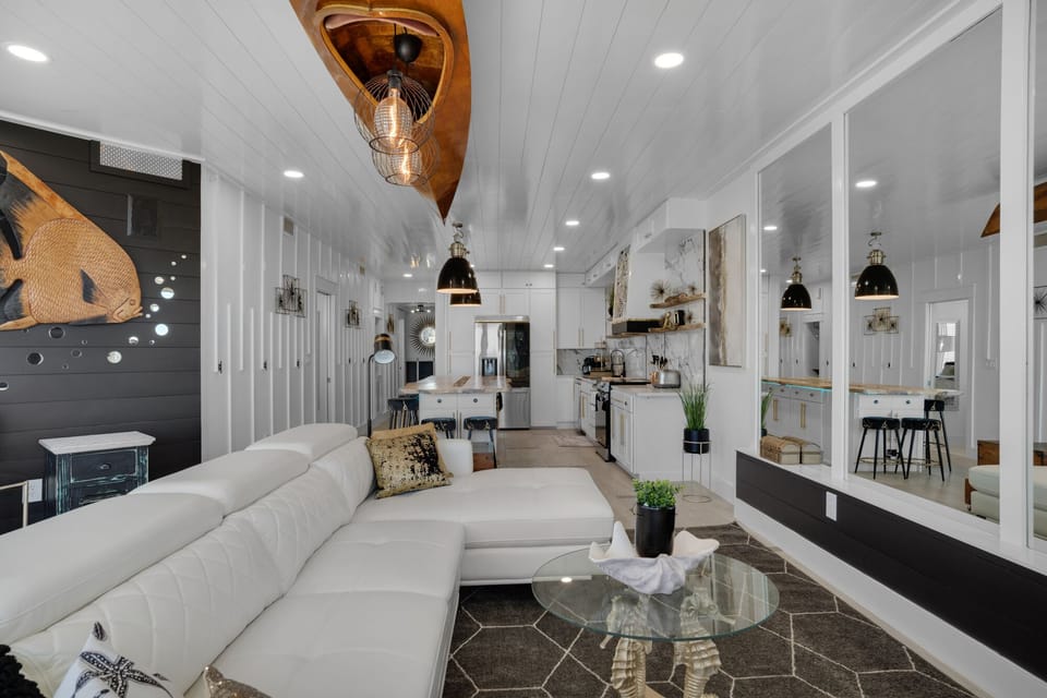 Sink into plush sofas in your stunning open-plan living space, where modern elegance meets cozy comfort under soaring ceilings.