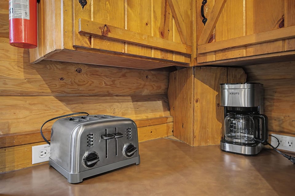 Start your mornings with fresh coffee and toast in this cozy cabin kitchen corner, where rustic wood meets modern convenience.