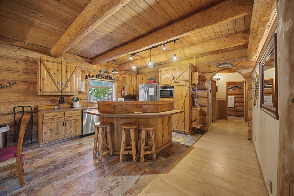 Step into this rustic log cabin kitchen where warm wood surrounds you, creating the perfect space for cooking memorable meals together.