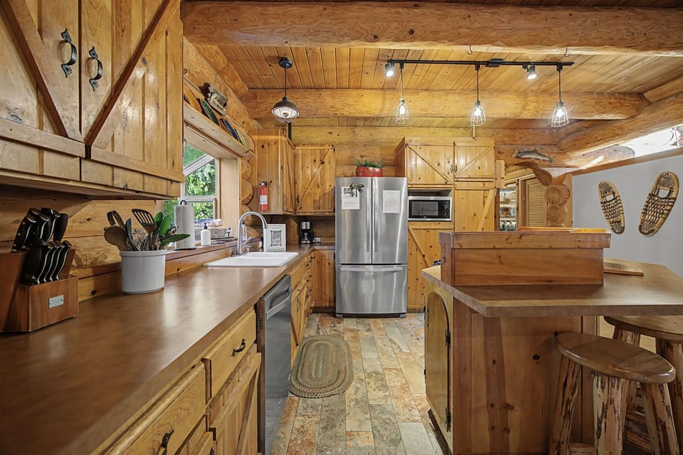 Your rustic kitchen invites culinary adventures with warm wood, modern appliances, and charming cabin touches throughout.
