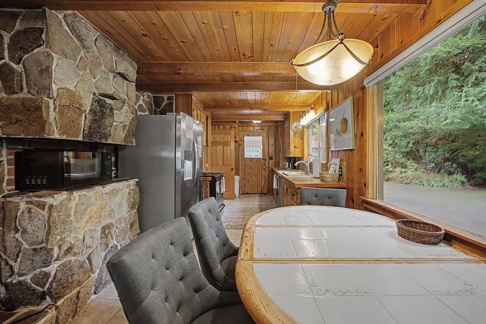 Cozy up in this rustic cabin where warm wood beams meet a stunning stone fireplace, creating your perfect mountain retreat.
