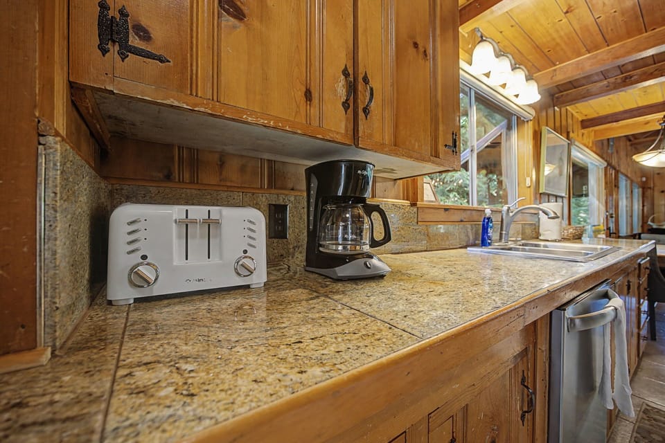 Start your mornings with fresh coffee and toast in this charming rustic kitchen, complete with granite counters and warm wood cabinets.