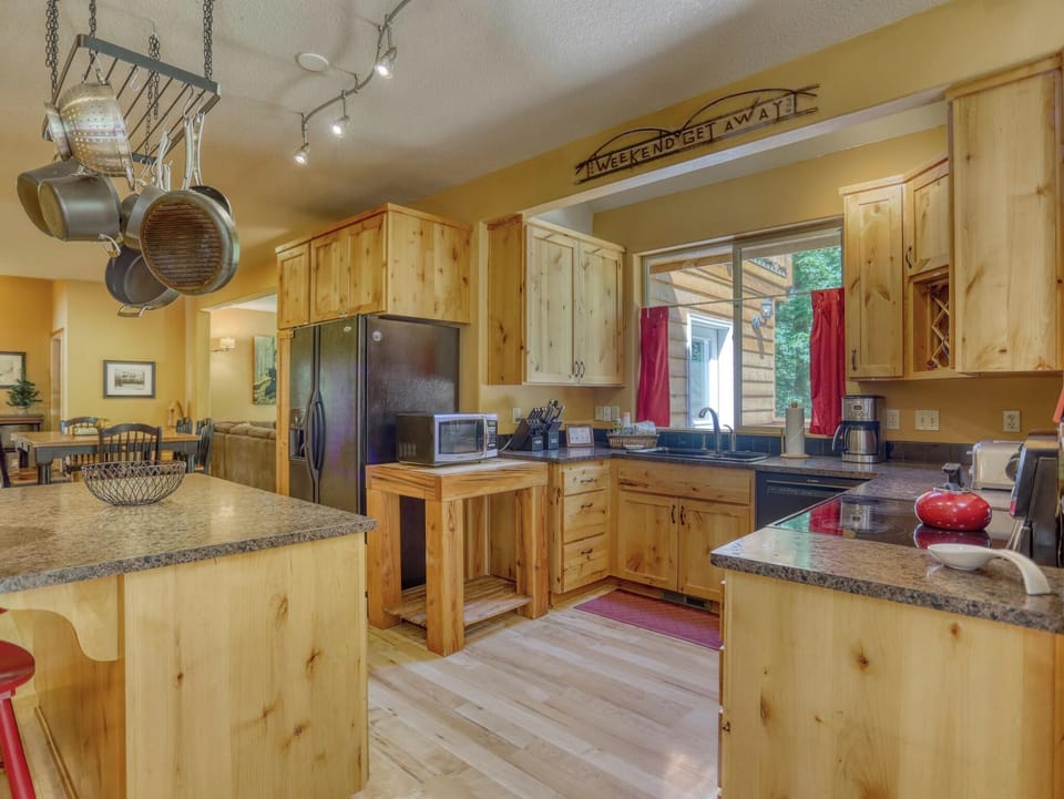 Your rustic-chic kitchen awaits, complete with granite countertops, custom cabinetry, and modern appliances—perfect for preparing meals together while soaking in natural light from the windows.