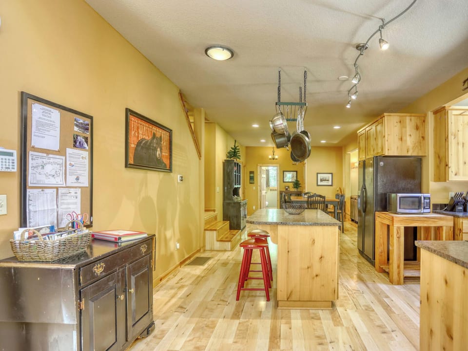 Step into a fully equipped kitchen where rustic wooden cabinetry meets modern convenience, featuring a granite island with bar seating perfect for casual meals and gathering.