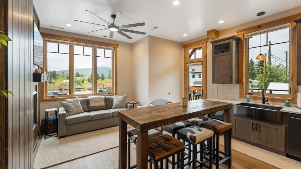 Open concept living room and dining area, with gas fireplace, luxury American Leather sofa sleeper (no bars and luxury mattress), HDTV with streaming capabilities, and views of Big Mountain