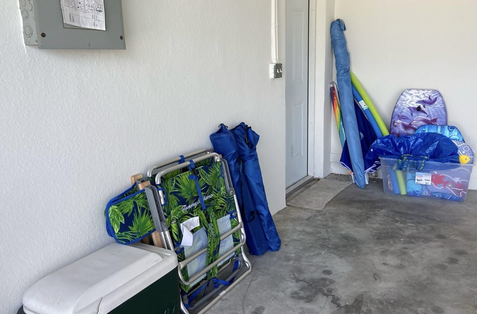 Chairs, cooler, boogie boards, and sun umbrellas.