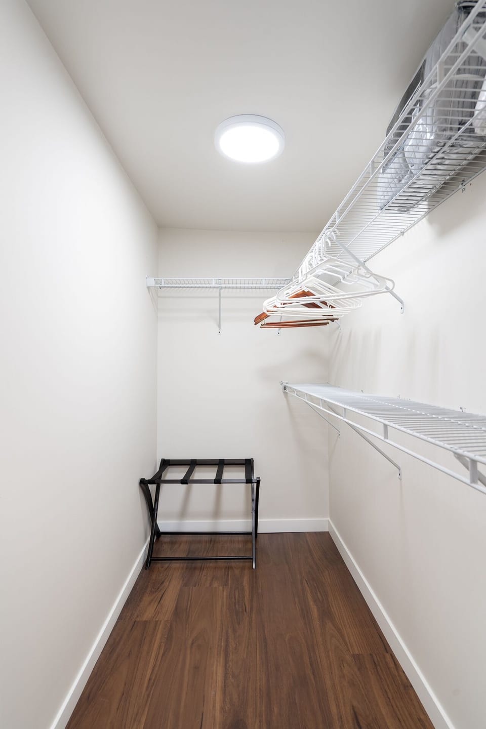 Your walk-in closet offers abundant storage with wire shelving and hanging space, keeping your wardrobe organized throughout your stay.