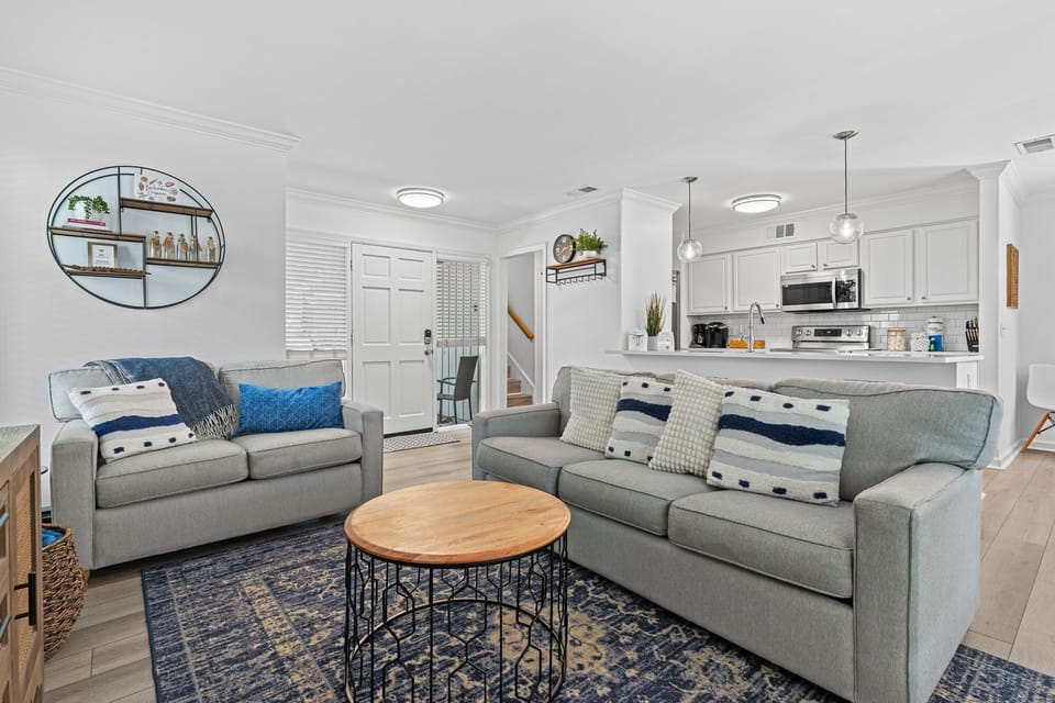 Living room with open concept to kitchen, dining and sliders to backyard