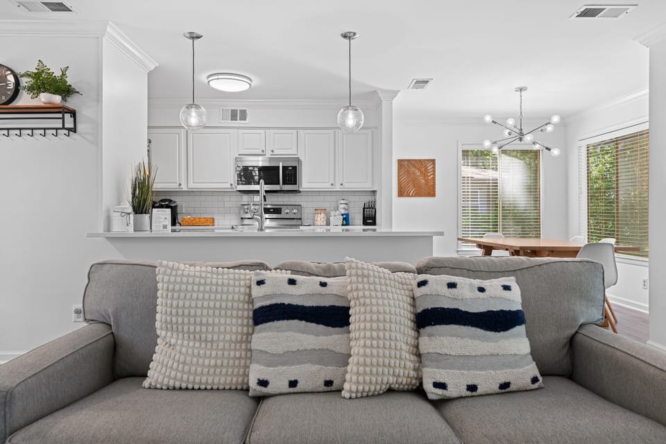 Living room with open concept to kitchen, dining and sliders to backyard