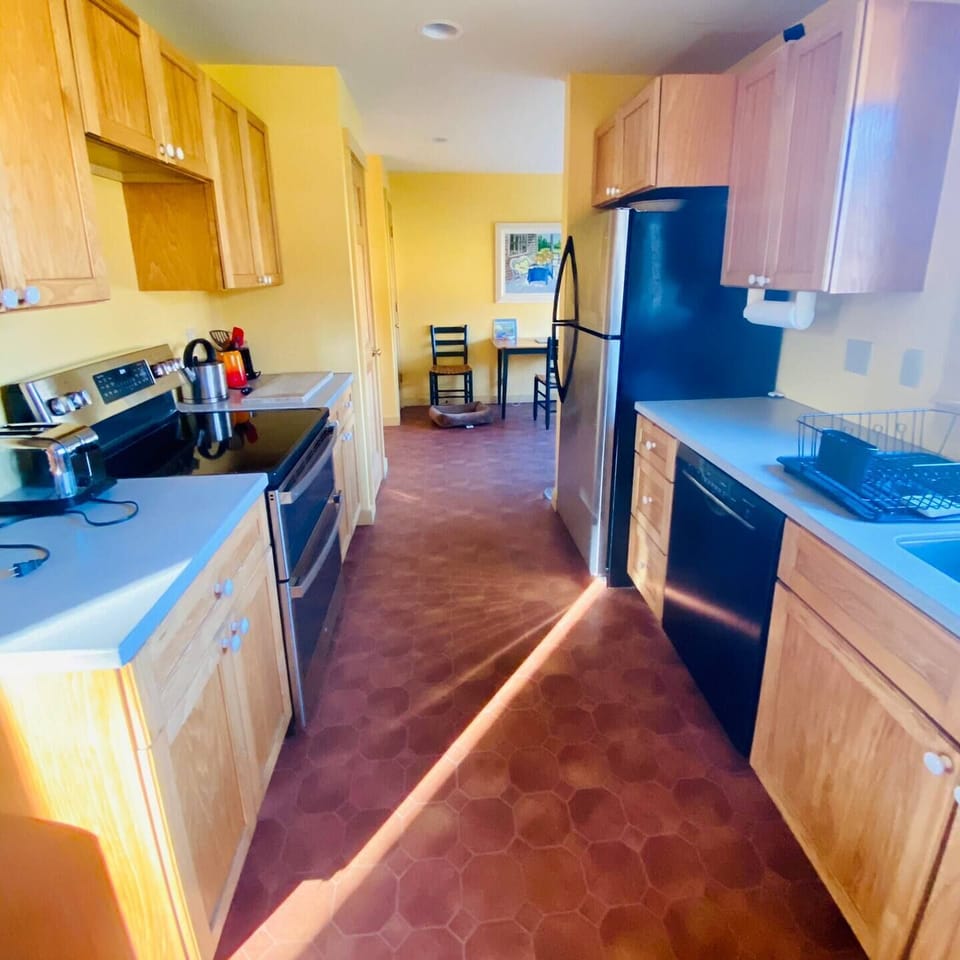 Kitchen w/ new stove and dishwasher, breakfast nook in back to right