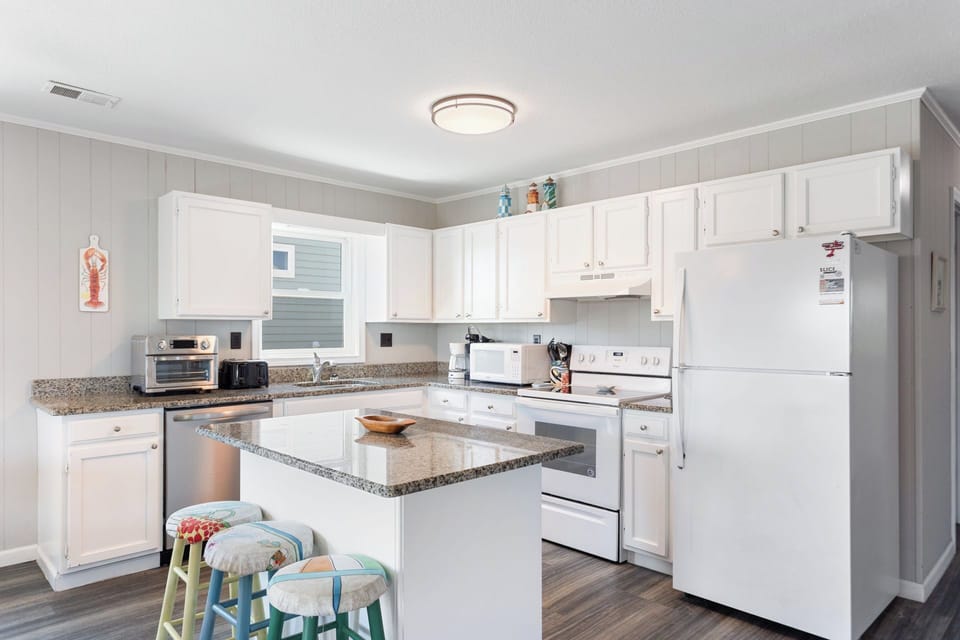 Whip up something delicious in the modern Kitchen with a flat-top stove and bar seating for 3!
