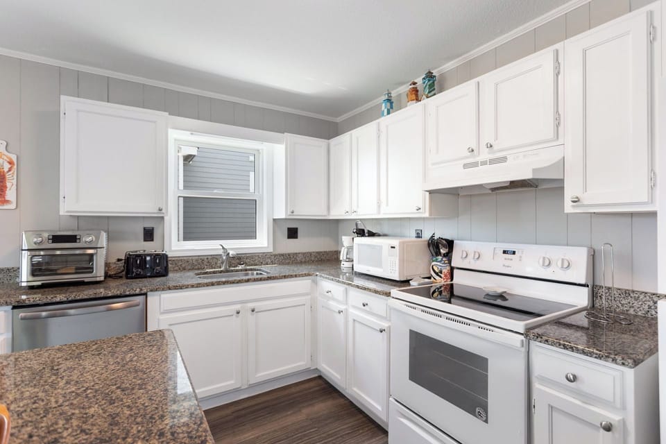 Whip up something delicious in the modern Kitchen with a flat-top stove and bar seating for 3!