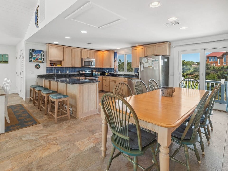 Enjoy open-concept dining with the well-stocked Kitchen and two dining tables.