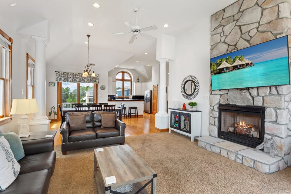 Relax in the spacious Living Area with a fireplace, flat-screen TV, and deck access. (Please Note: Fireplace is not for guest use)