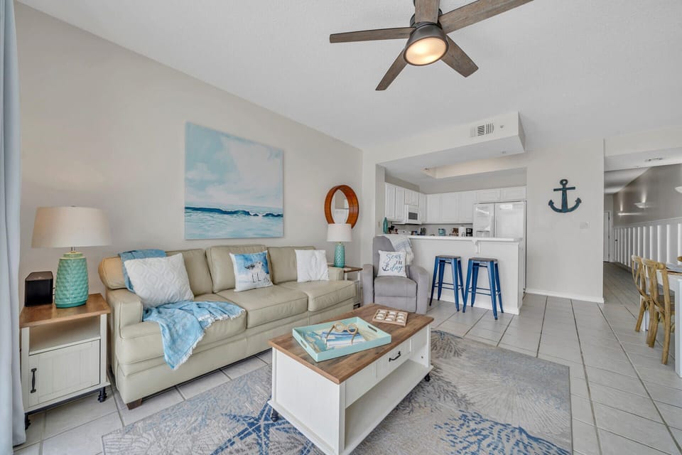 Relax in your coastal-themed living space with nautical touches, comfortable seating, and an open kitchen perfect for beach getaways.