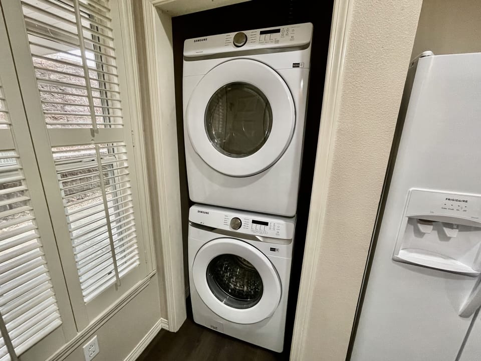 Large front loading washer and dryer with laundry soap and dryer sheets.