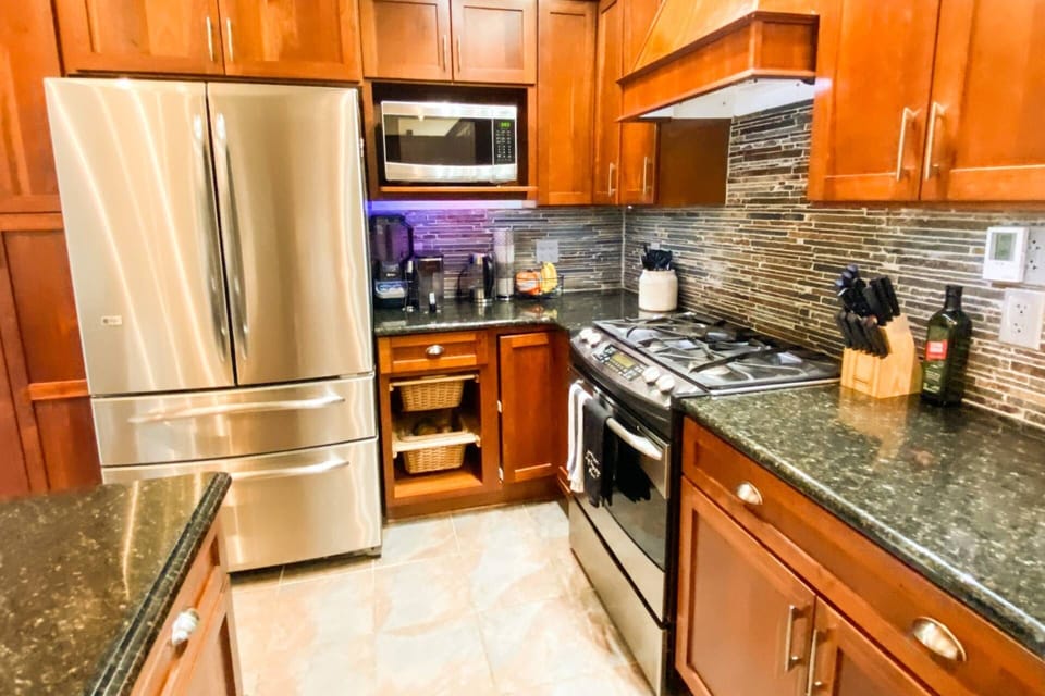 The kitchen's high-end appliances include a gas stove, coffee maker, microwave, toaster, hand mixer and blender.