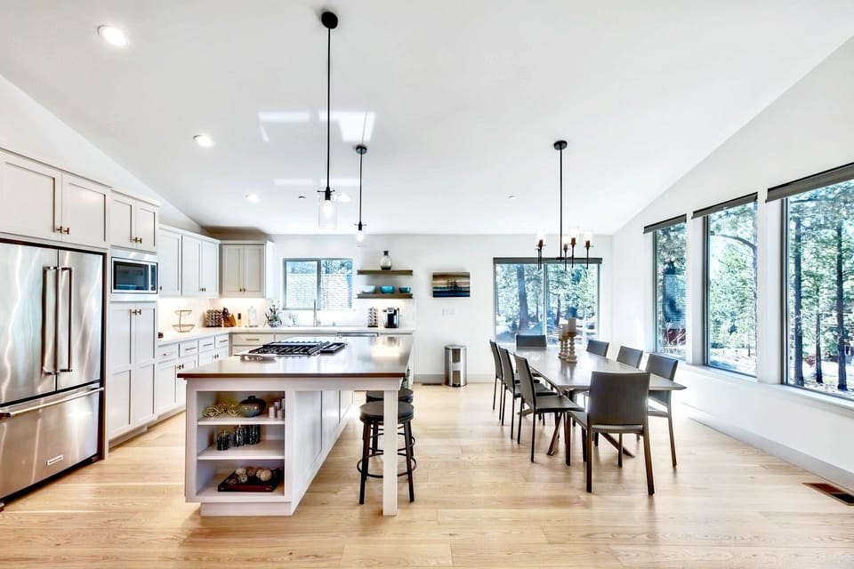 This cozy kitchen layout includes a casual dining table with chairs, creating a warm space for everyday meals with natural light and high-end finishes throughout.
