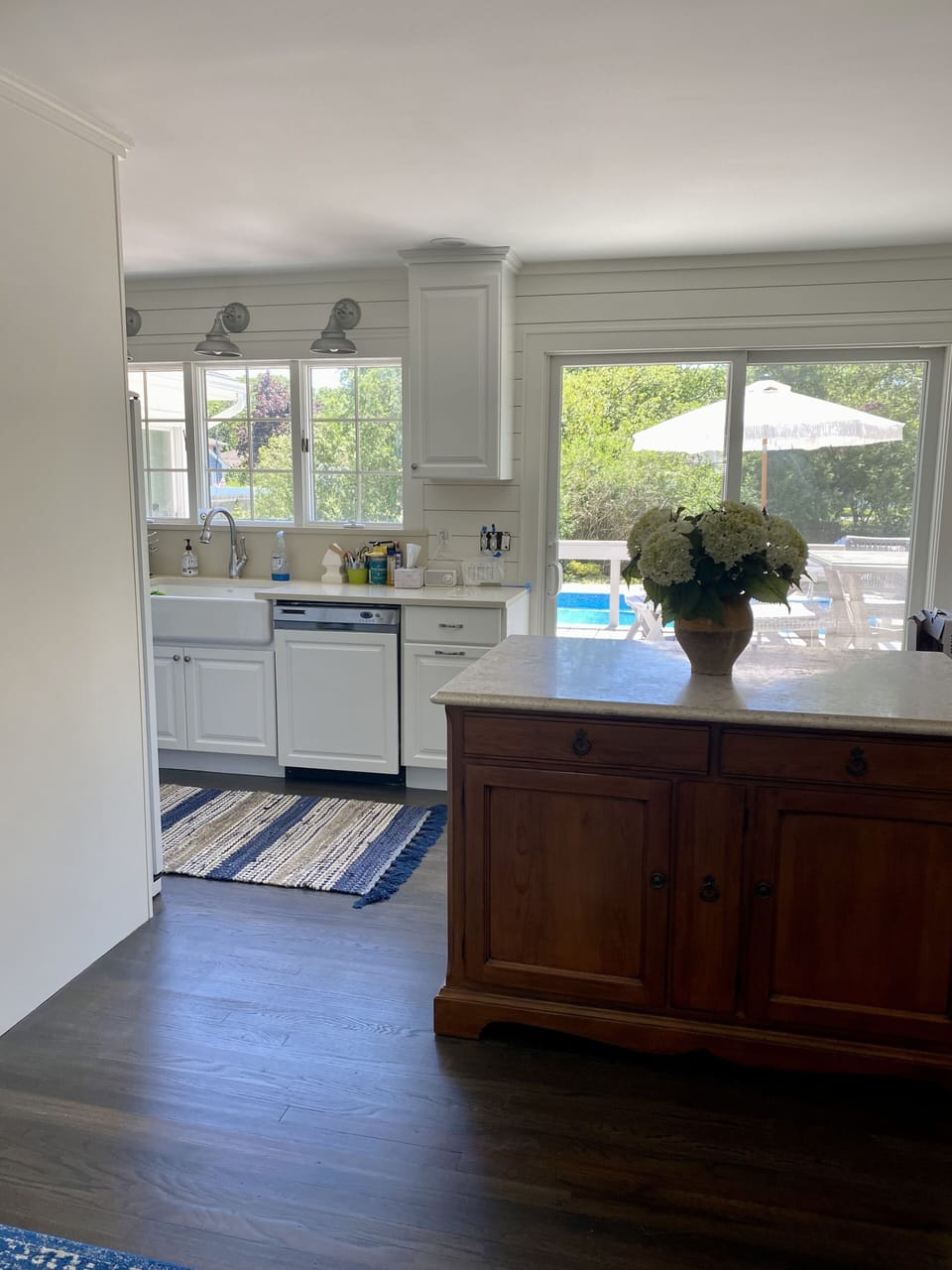 Sun soaked kitchen overlooking pool & walk out to deck with string lights 