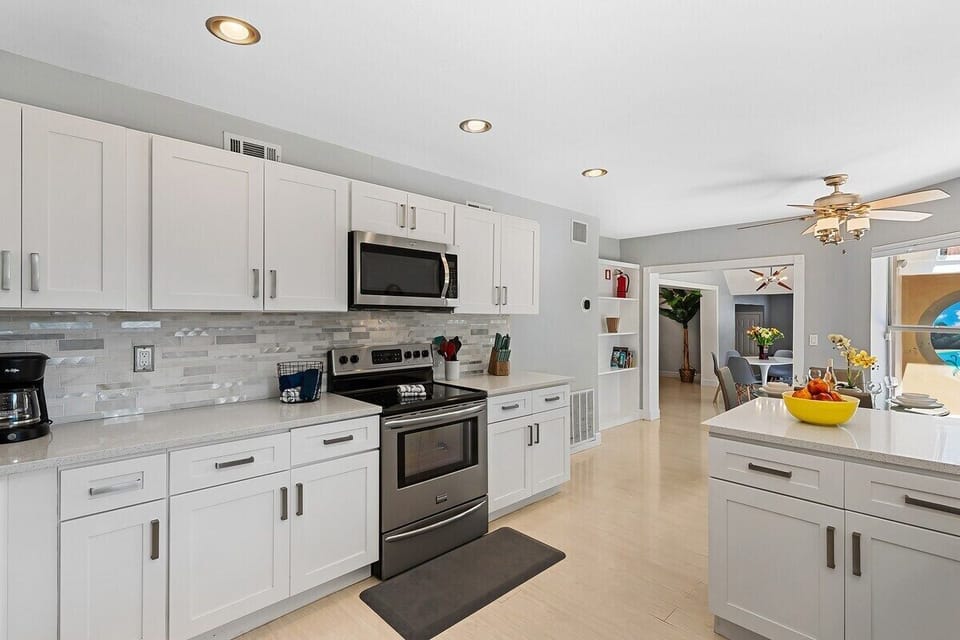 Prepare a family meal in the fully-equipped custom kitchen offering bar seating, dining table seating, updated appliances and sunny backyard patio views.