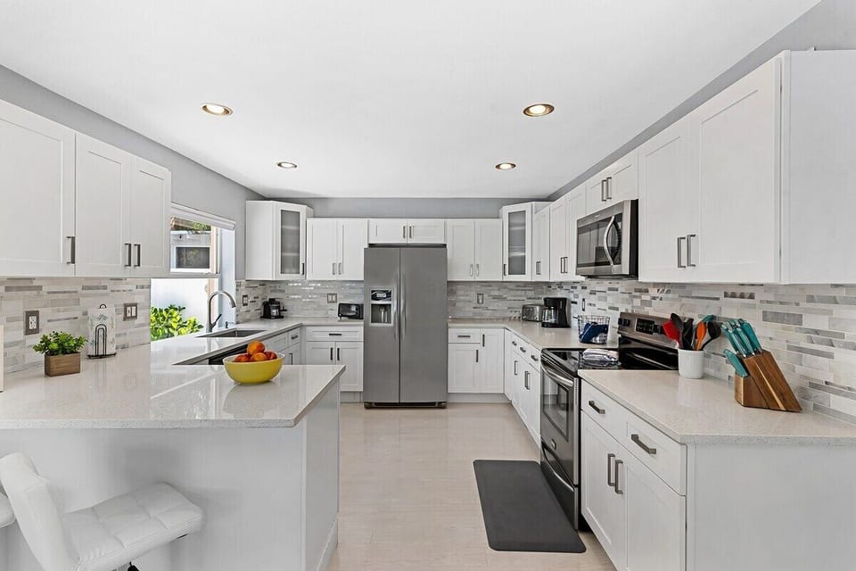 Prepare a family meal in the fully-equipped custom kitchen offering bar seating, dining table seating, updated appliances and sunny backyard patio views.