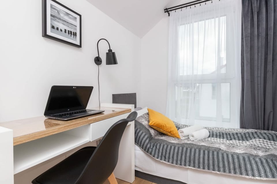 A compact bedroom with a single bed, gray and yellow accents, and a cozy, functional design.