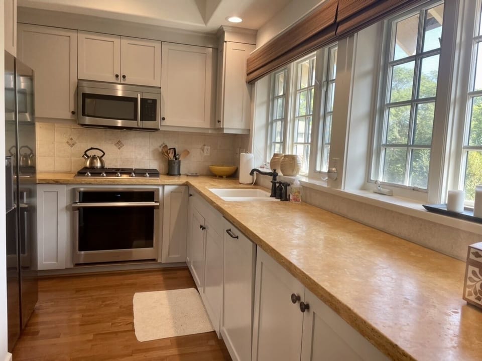 Kitchen equipped with new stainless steel appliances and slab countertops