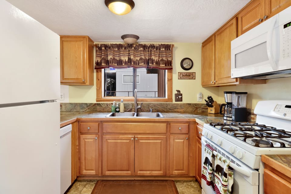 Fully equipped cabin kitchen with ample cabinetry, stove, fridge, microwave, and coffee maker—perfect for cooking meals, morning coffee, and feeling right at home on your stay.