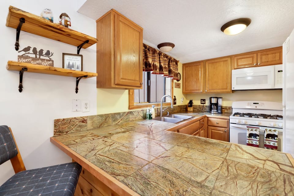 Fully equipped cabin kitchen with ample cabinetry, stove, fridge, microwave, and coffee maker—perfect for cooking meals, morning coffee, and feeling right at home on your stay.