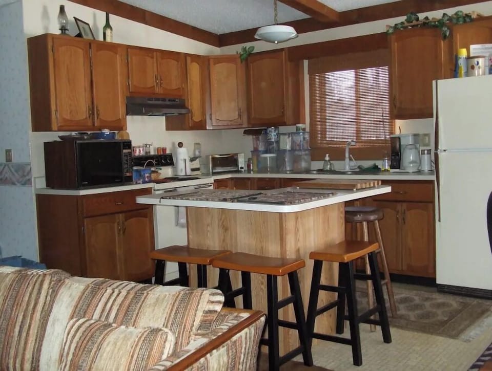 Fully stocked kitchen with additional island seating beyond kitchen table.  
