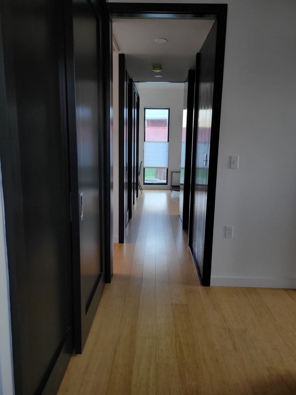 The hallway from bedroom 2 looking through to bedroom 1.  BR on the right.