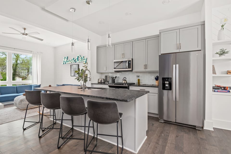 Stunning kitchen with stainless appliances, a seated bar, and a formal dining space