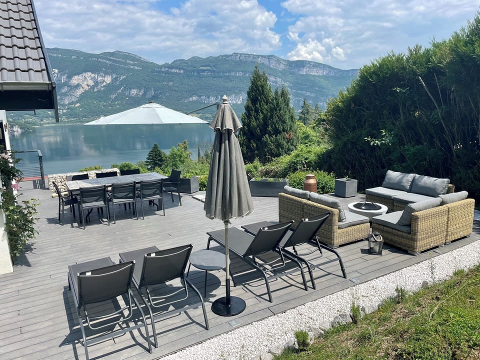 Terrace with dining table, sun loungers and sofas. 