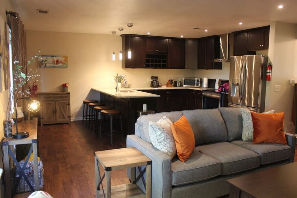 Experience the perfect fusion of comfort, functionality, and style in our short-term rental's living room with a joint kitchen and dining area. This seamless integration of spaces creates an open and inviting atmosphere.