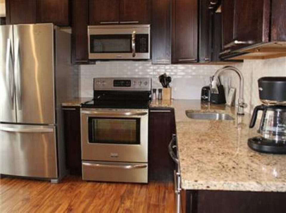 Embrace the art of culinary excellence in our short-term rental's fully equipped kitchen, featuring sleek stainless steel appliances. Step into a culinary haven where every detail is designed with both functionality and style in mind.