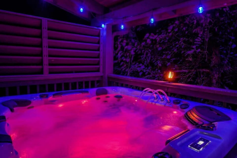 Outdoor hot tub with colorful LED lighting for a relaxing evening.