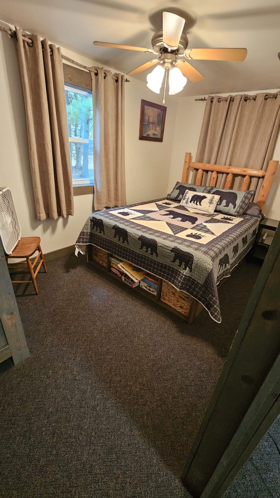 Bedroom 2 with a queen bed, ceiling fan, and a window box fan.