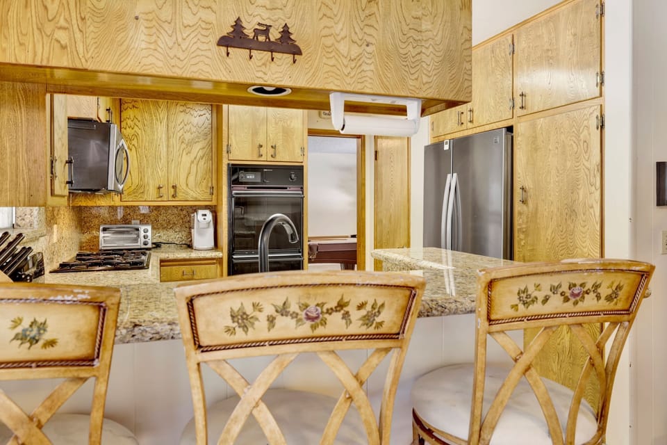 Fully equipped cabin kitchen with ample cabinetry, stove, fridge, microwave, and coffee maker—perfect for cooking meals, morning coffee, and feeling right at home on your stay.