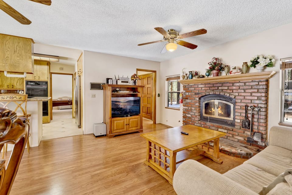 Cozy mountain living room with a  stone fireplace, comfy seating, and smart TV—perfect for relaxing evenings, movie nights, and warm cabin vibes after outdoor adventures.