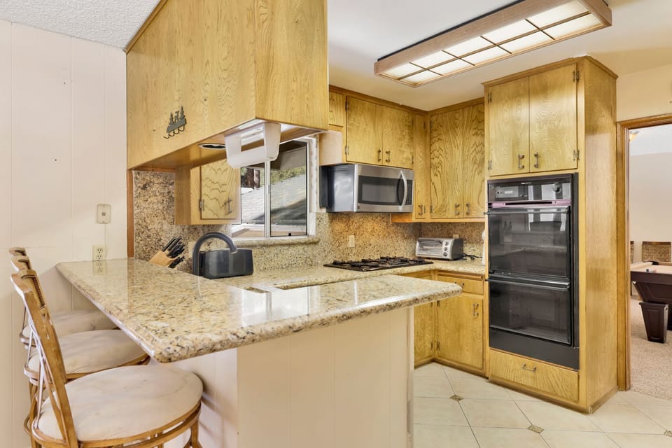 Fully equipped cabin kitchen with ample cabinetry, stove, fridge, microwave, and coffee maker—perfect for cooking meals, morning coffee, and feeling right at home on your stay.