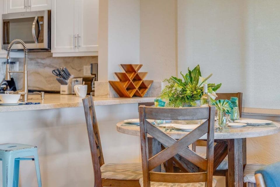 Bright dining space with seating for four, surrounded by natural light and tropical views for a relaxing meal
