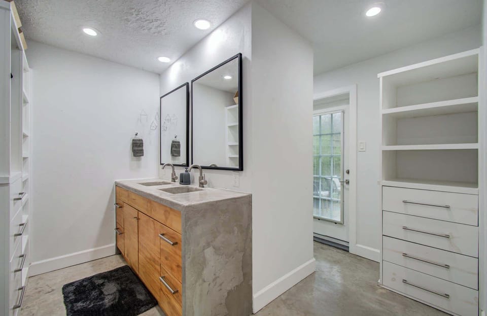 You’ve never seen a bathroom as unique as this one, with dual vanities, ample built-in shelving, and direct access to the backyard!