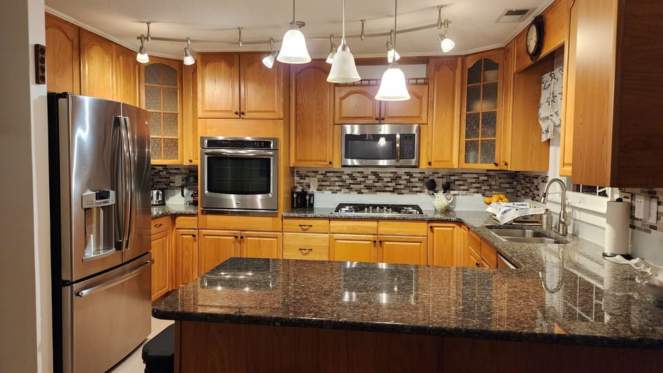 Well stocked kitchen with appliances, dishes and plenty of cookware.