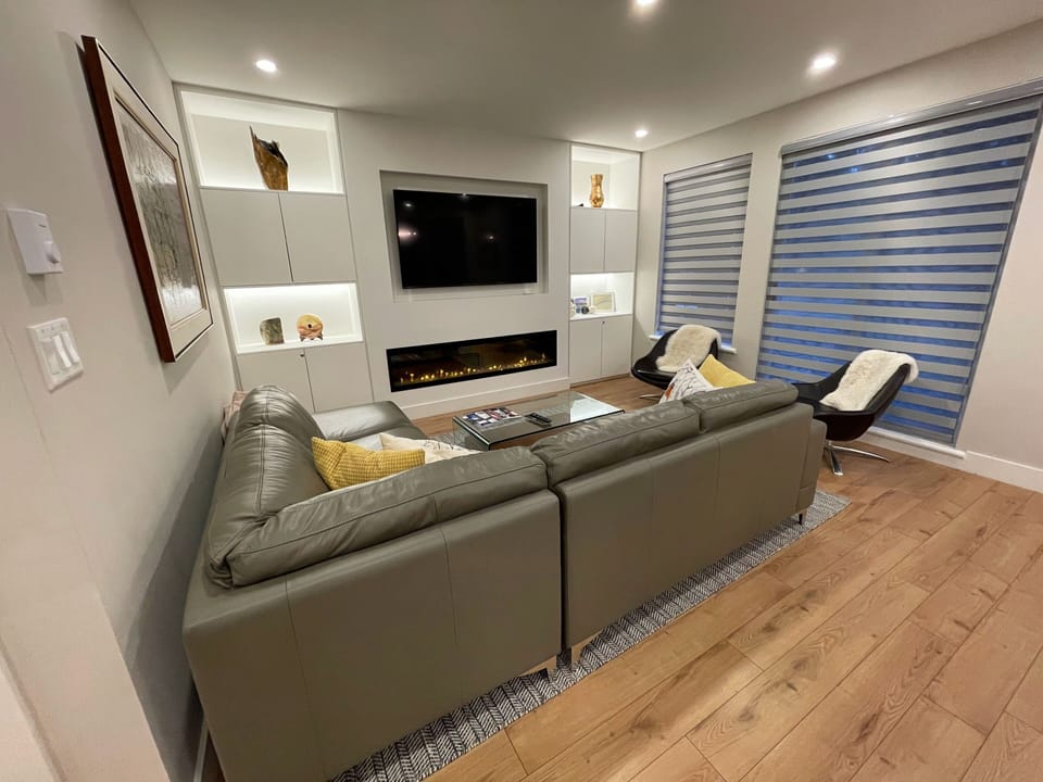 Living room with 65" Smart TV and electric fireplace with comfortable seating